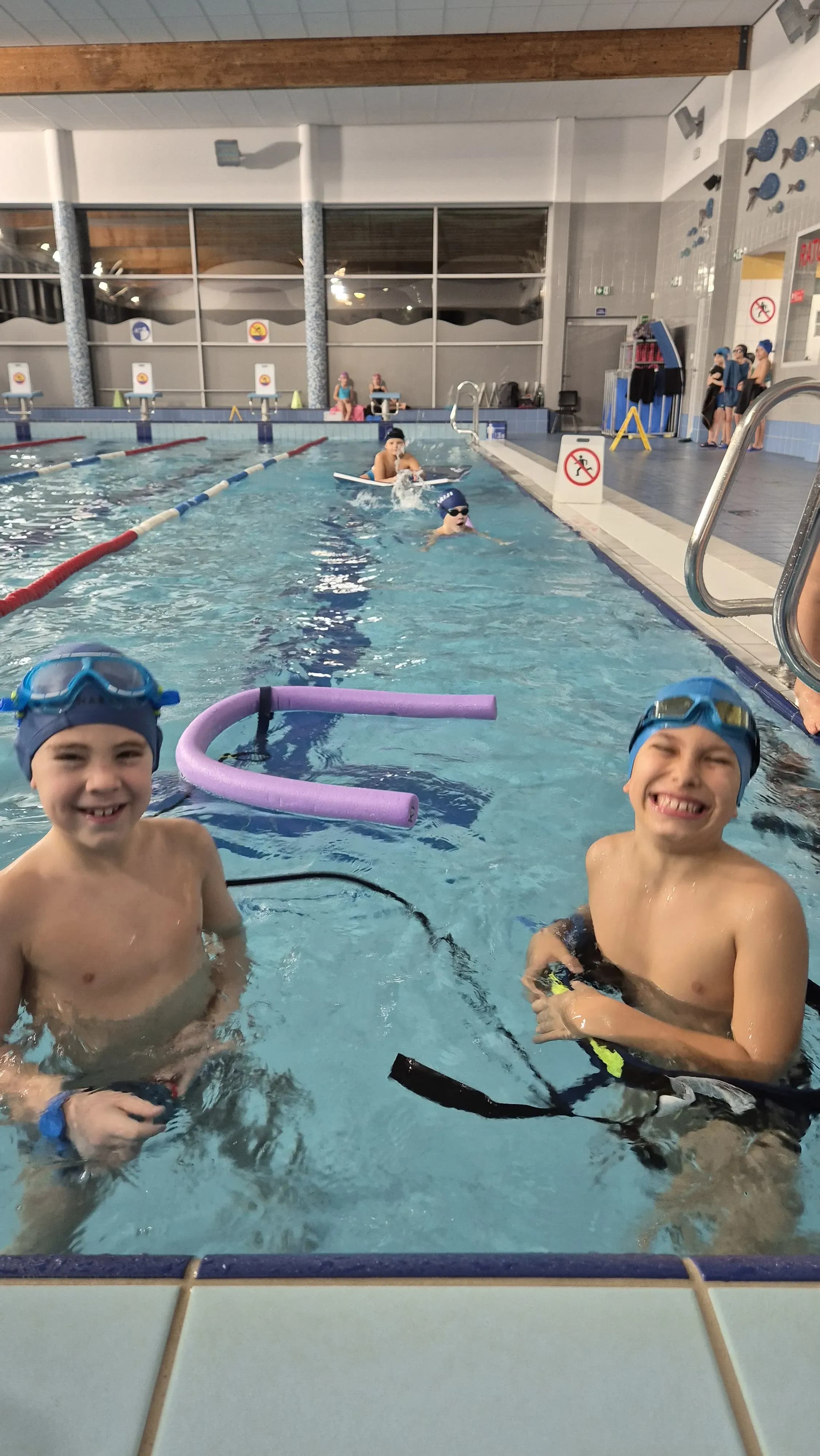 Uśmiechnięci chłopcy podczas zajęć na basenie